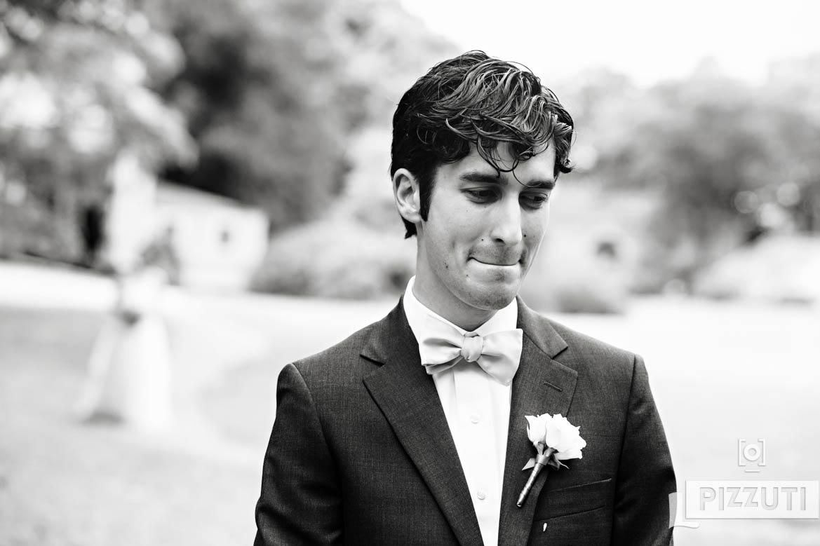 Groom waits for his bride during a first look at the Lyman Estate.